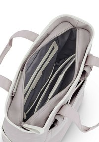 Bolsa de mano de color morado claro con un exterior suave, acentos en blanco y múltiples compartimentos interiores grises, incluyendo bolsillos con cremallera y bolsillos deslizables.