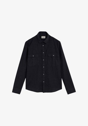 Camisa negra de manga larga con botones, con dos bolsillos de solapa con botón en el pecho y un cuello estándar, colocada plana sobre un fondo blanco.