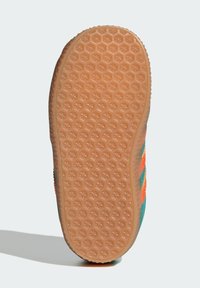 Sko sula av texturerat gummimaterial med ett hexagonalt mönster. Sidorna visar en färgskala av grönt, rött och orange.
