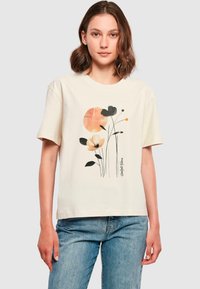 Cream cotton t-shirt featuring a floral design with a large orange circle. Relaxed fit, short sleeves, and a slightly textured graphic print.