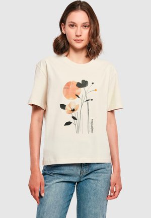 Cream cotton t-shirt featuring a floral design with a large orange circle. Relaxed fit, short sleeves, and a slightly textured graphic print.