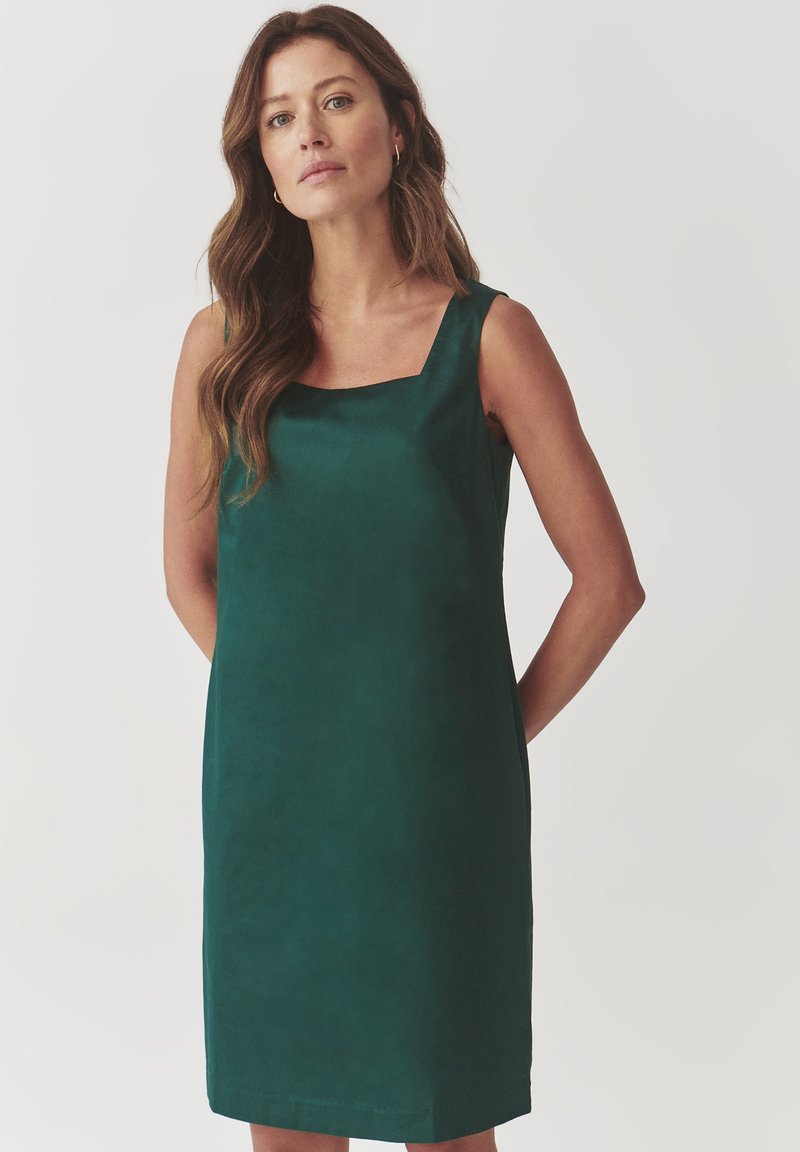 Green sleeveless dress with a squared neckline, made from smooth fabric. Simple, straight silhouette reaches mid-thigh. No notable patterns.