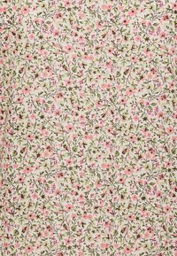 Tela floral con pequeñas flores rosas y hojas verdes sobre un fondo beige. El diseño es denso con patrones naturales intrincados.