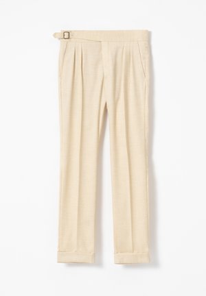 Pantalones beige a medida con pinzas delanteras, bolsillos laterales, dobladillos con vuelta y hebilla lateral ajustable en la cintura.