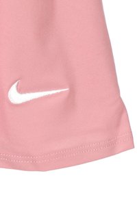 Rózsaszín pamut póló, lekerekített aljjal, fehér hímzett Nike logóval a bal oldalon. Simogató tapintás, hétköznapi dizájn.