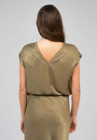 Robes en satin vert olive avec un profond dos en V, des manches courtes et une texture lisse, présentant une taille cintrée et un design drapé.