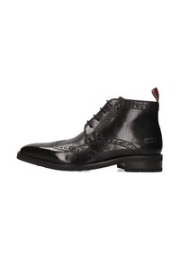 Botas de tobillo de cuero negro con un acabado pulido, diseño con puntera alada, detalles de brogue, seis ojales y una lengüeta de múltiples colores en la parte posterior.
