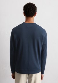 Námořnické modré sweatshirt s dlouhým rukávem, oblečením kulatým výstřihem, manžetami a lemem s ribbed texturou. Měkká struktura, minimalistický design, žádné viditelné logo.