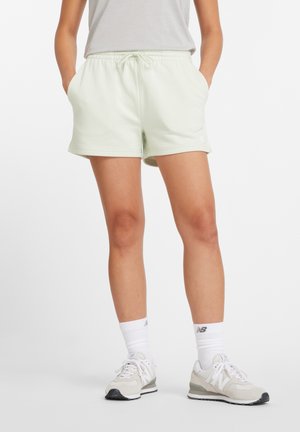 Pantalones cortos de algodón verde claro con cintura elástica y cordón, que cuentan con bolsillos laterales y un pequeño logo blanco en el dobladillo.