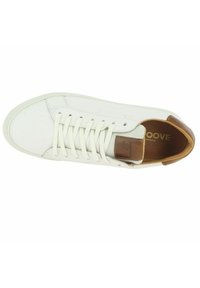 Baskets blanches avec une tige en cuir lisse, des lacets et un accent de talon en cuir beige. Comprend un capuchon de pied texturé et une semelle intérieure rembourrée.