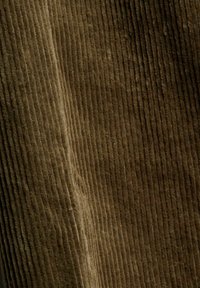 Tissu en velours côtelé marron avec des rainures verticales et une surface douce et texturée.