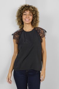 Črna majica z prosojnimi čipkastimi rokavi in okroglim izrezom. Gladka tekstura z udobnim krojem, v kombinaciji s temno modrimi jeans hlačami.