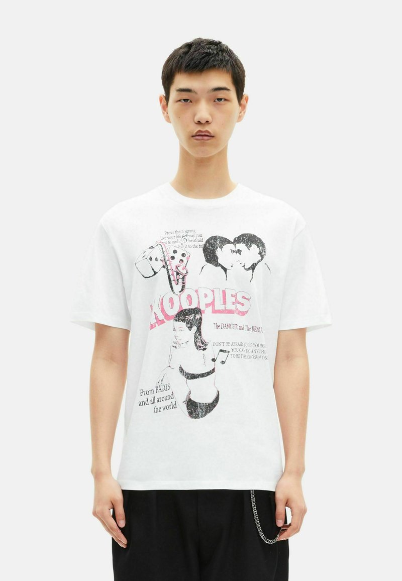 White cotton T-shirt featuring graphic prints in black and pink, with text and illustrations, relaxed fit, short sleeves, round neckline.