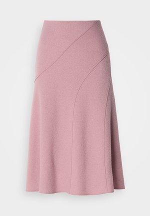 Rosa A-lijn rok gemaakt van gestructureerde stof, met diagonale naden en een aansluitende taille. De zoom valt net onder de knie.