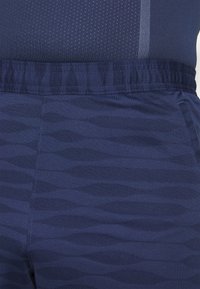 Navy blue joggers featuring a wavy pattern, elastic waistband, and soft texture; designed for comfort and flexibility in movement.