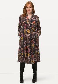 Langärmliges, gemustertes Kleid aus dunklem Stoff mit Wirbeln aus Pink, Gelb und Orange. Verfügt über einen Kragen, eine Knopfleiste und seitliche Taschen.