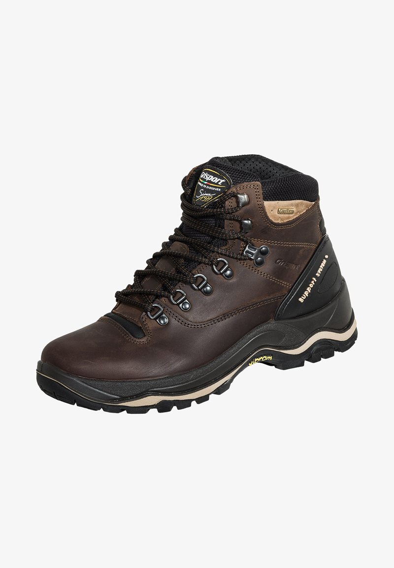 Braune Lederwanderstiefel mit Metallaugen, schwarzen Schnürsenkeln, gepolstertem Kragen und einer robusten Gummisohle mit Vibram-Branding.