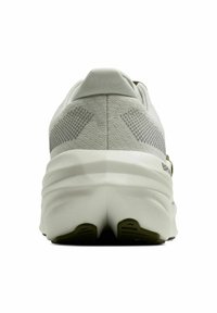 White athletic sneaker with a textured mesh upper, rounded heel, and a cushioned sole. Features minimal accents and a smooth finish.