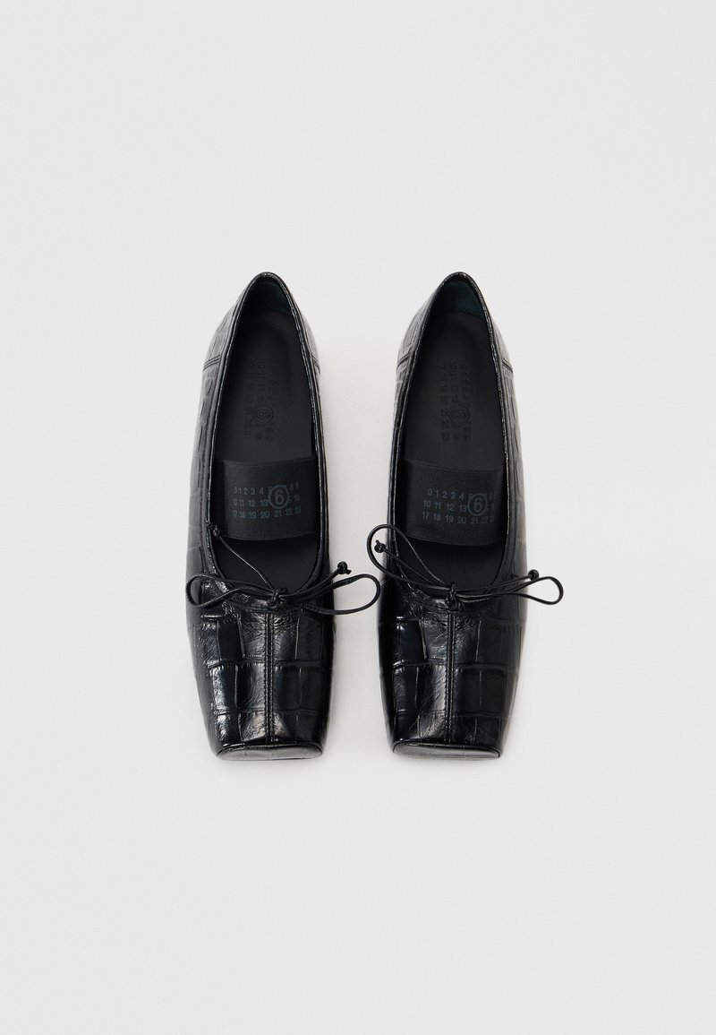 Black, leather ballet flats with a textured croc pattern, square toe, and bow detail on the front. Inner sole shows size markings.