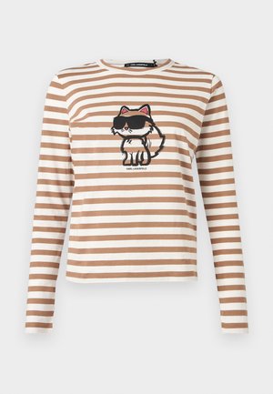 Hosszú ujjú, bézs és fehér csíkos ing, amelyen a mellrészen napszemüveget viselő rajzfilmmacska van nyomtatva.