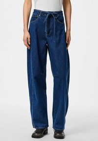 Srednje niske plave traperice slobodnog kroja s pojasom na vezanje, pet džepova i šavnim detaljima. Teksturirani materijal.