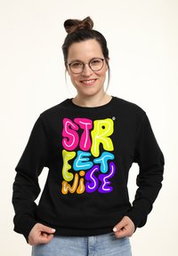 Zwarte sweatshirt met multikleurige tekst "STREET WISE" in verschillende bubbelachtige lettertypen. Smooth stof, ronde hals en lange mouwen.