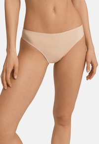 Slip bikini nudo con un design liscio e senza cuciture, realizzato in materiale elasticizzato. Presenta un vita bassa e una cucitura a copertura minima.