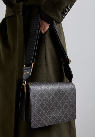 Sac en cuir noir en bandoulière avec un motif géométrique, présentant une finition texturée et une sangle tissée avec des accents en métal doré.