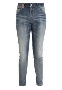 Jeans ajustados de denim, con un lavado azul medio, detalles de desgaste y un lazo de cuero marrón en la cintura. Incluye bolsillos frontales.