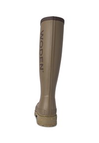 Bota alta de goma verde con un borde texturizado marrón, que presenta un logotipo "WODEN" en negrita en el lado y una suela estampada para ofrecer tracción.