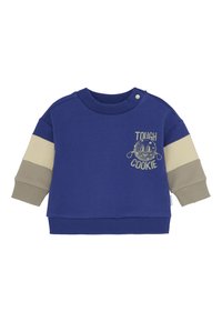 Sweatshirt bleu pour enfants avec des manches beige et taupe, bouton près du col et texte "Tough Cookie" accompagné d'un graphique de cookie sur la poitrine.