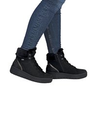 Bottines noires en daim avec col en fausse fourrure, lacets et fermeture éclair, dotées d'une semelle en caoutchouc texturée pour une bonne adhérence.