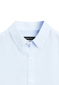 Chemise bleu clair à col boutonné avec des boutons blancs et une étiquette noire visible portant l'inscription « Massimo Dutti ».