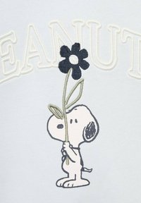 Snoopy drži črno rožo z zelenim steblom in listi, stoji pod belimi obrobnimi črkami na svetlo sivi podlagi.