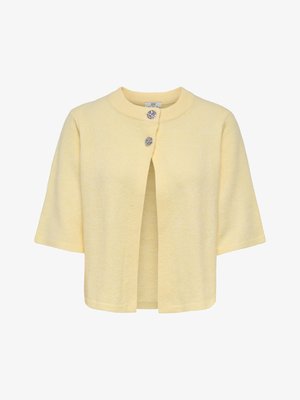 Cardigan à manches courtes jaune clair avec encolure ronde et deux boutons décoratifs argentés en haut de l’ouverture avant.