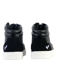 Sneaker nere alte in suede e materiali sintetici, con suola bianca, collo imbottito e dettaglio del logo sul tallone.