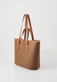 Sac fourre-tout en matériau synthétique brun avec un motif texturé en relief. Présente deux longues poignées et un intérieur rose contrastant.