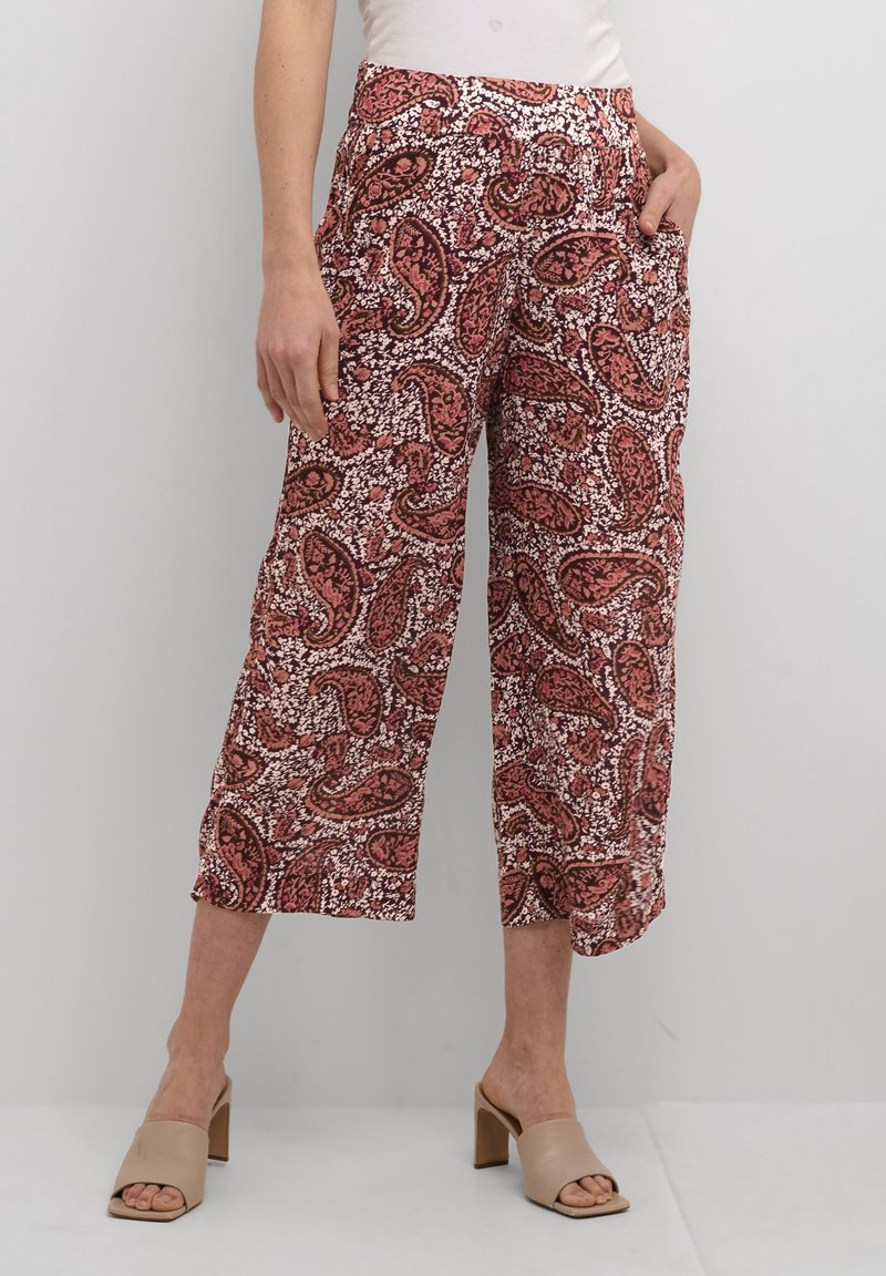 Pantalons courts à motif paisley rouge et blanc, avec une coupe décontractée, présentant des poches latérales et un tissu léger.