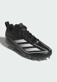Scarpa sportiva nera con tomaia sintetica, caratterizzata da strisce bianche, design con lacci, superficie testurizzata e tacchetti trasparenti stampati sul fondo.