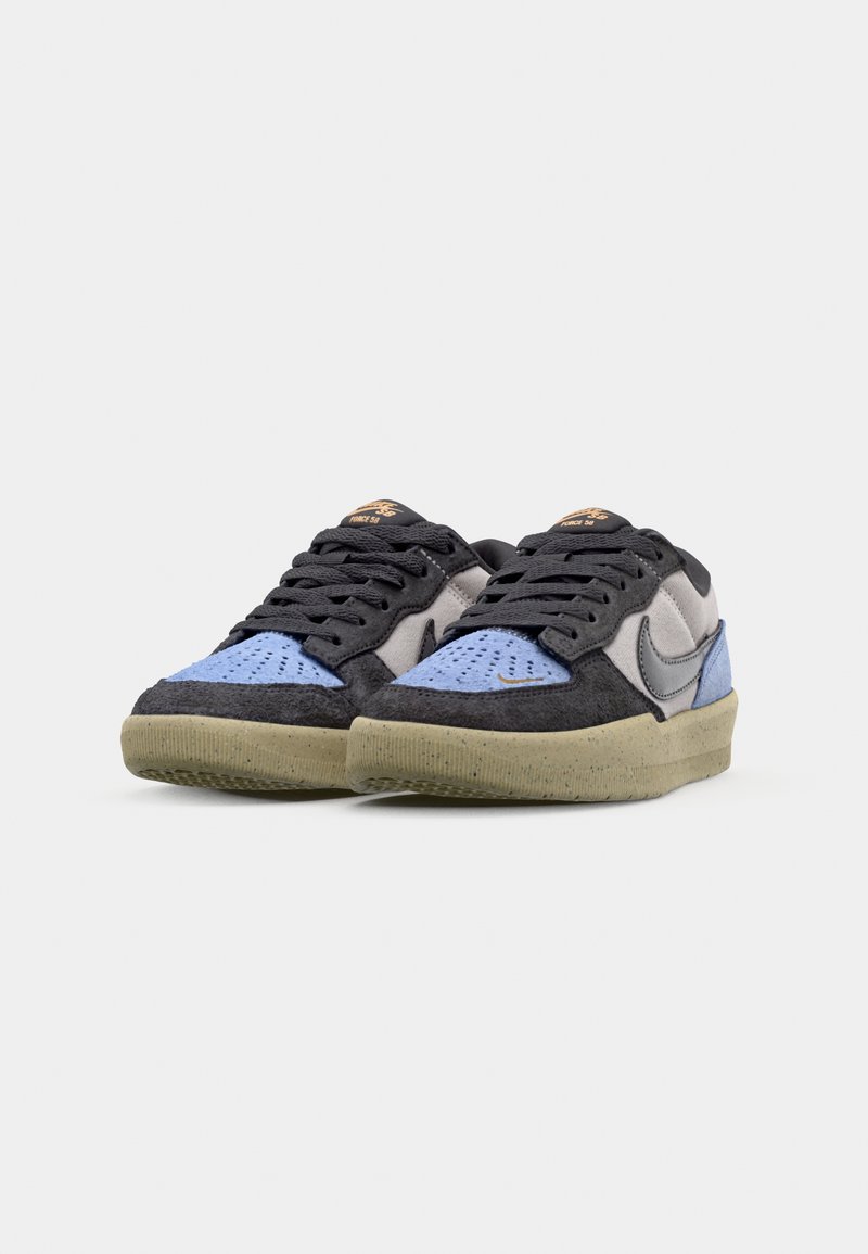Sneakers Nike w mieszance czarnego, szarego i niebieskiego zamszu, z teksturowaną cholewką i jasnoniebieską, nakrapianą podeszwą.