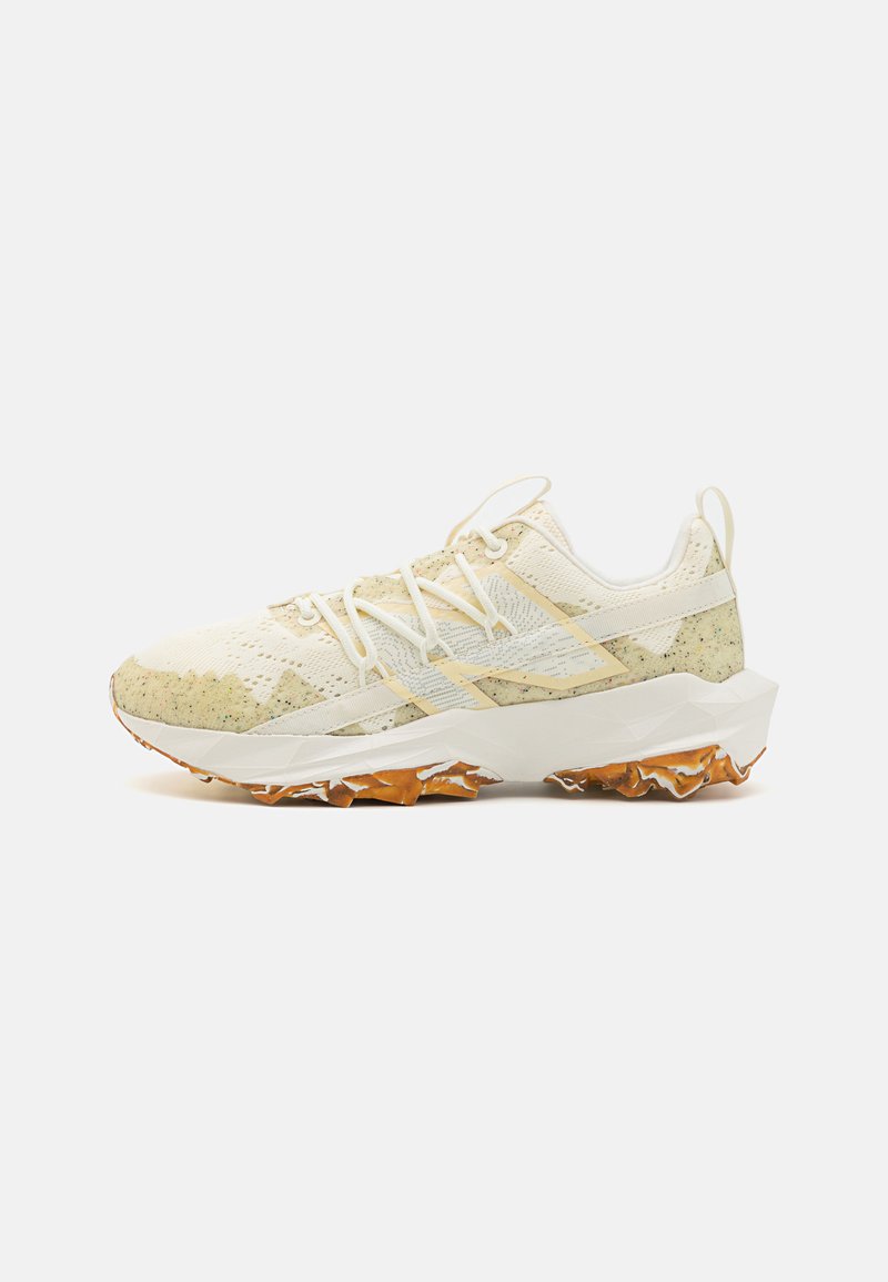Atletiek schoenen in lichtcrème met gespikkelde groene accenten. Voorzien van een mesh bovenkant, een gestructureerde rubberen zool en platte veters.