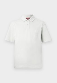 Λευκό πόλο με κοντά μανίκια, δύο κουμπιά, γιακά και μικρό κεντημένο λογότυπο στην αριστερή πλευρά του στήθους.