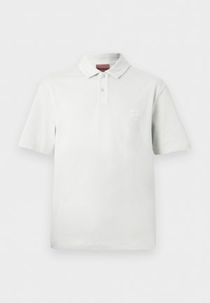 Biele polokošeľa s krátkym rukávom, dvoma gombíkmi, golierom a malým vyšitým logom na ľavej strane hrudníka.