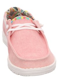 Scarpa di tela rosa con lacci e suola bianchi. L'interno presenta un motivo geometrico colorato. Forma arrotondata con una texture morbida.