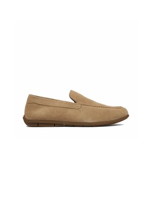 Hellbrauner Slip-On-Slipper aus Wildleder mit niedrigem Absatz, abgerundetem Zehenbereich und gesteppten Details entlang der Oberseite und Seiten.
