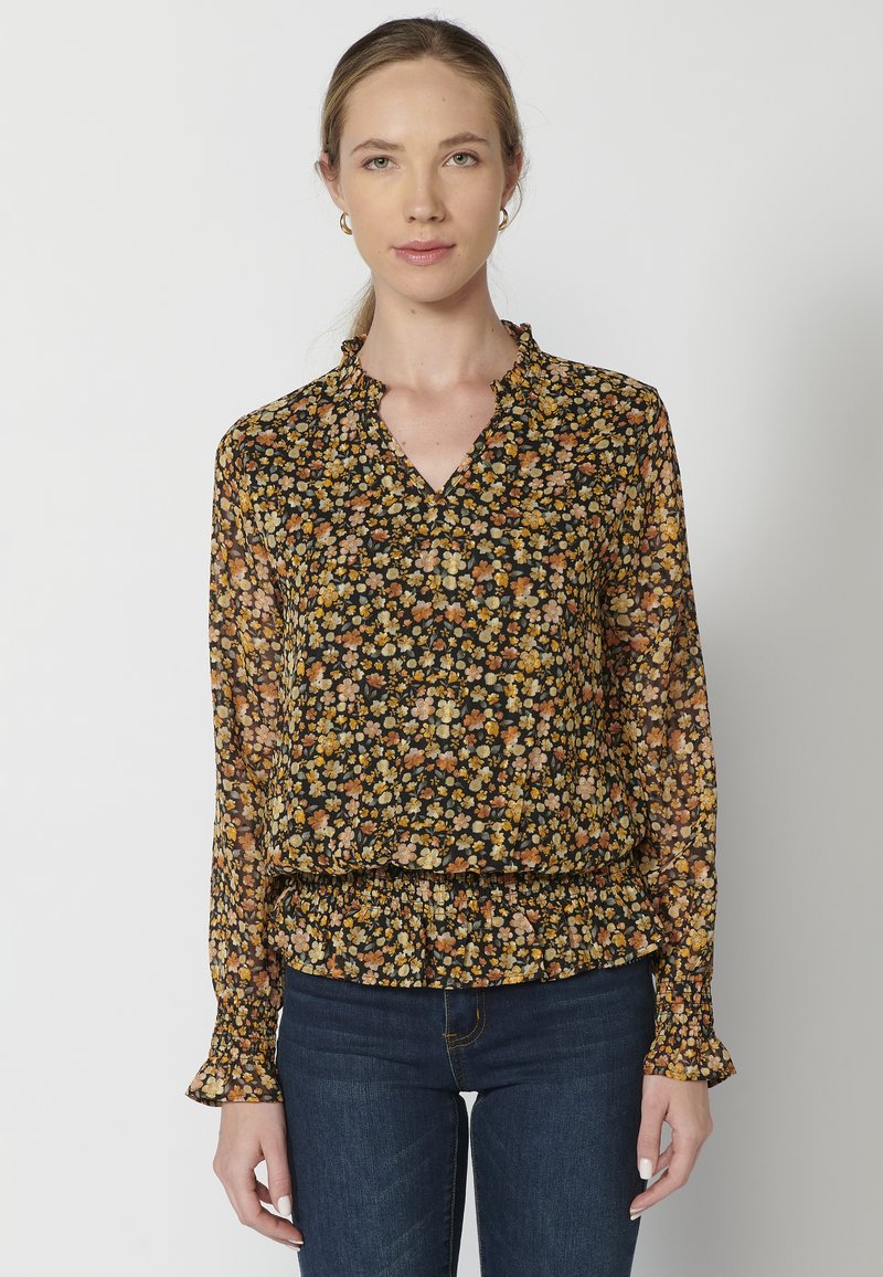 Blusa nera a fiori con maniche lunghe, scollatura arricciata, caratterizzata da piccoli fiori arancioni e gialli, tessuto semi-trasparente e orlo arricciato.