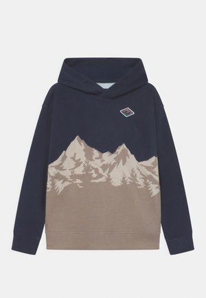 Marineblå og beige hættetrøje med grafisk billede af bjerg og træ på fronten samt lille diamantformet mærke nær venstre skulder.