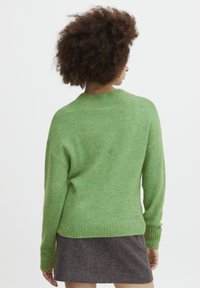 Green knit sweater with a relaxed fit, ribbed cuffs, and hem. Soft texture and lightweight material. Back view showcases a round neckline.