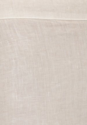 Tessuto di lino beige con una trama tessuta visibile e una cucitura piegata vicino al bordo superiore.