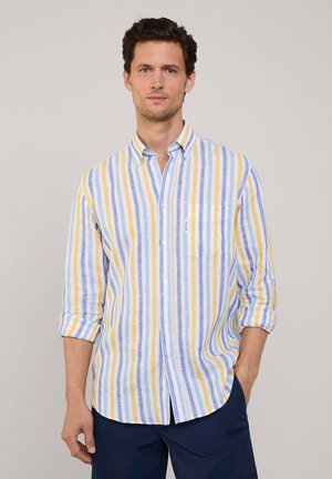 Camicia button-up in tessuto leggero con righe verticali blu, gialle e bianche. Maniche lunghe arrotolate, una tasca sul petto.
